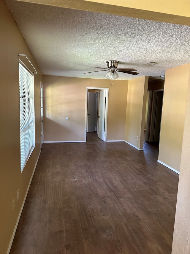 spare room featuring a textured ceiling, ceiling fan, and dark hardwood / wood-style flooring