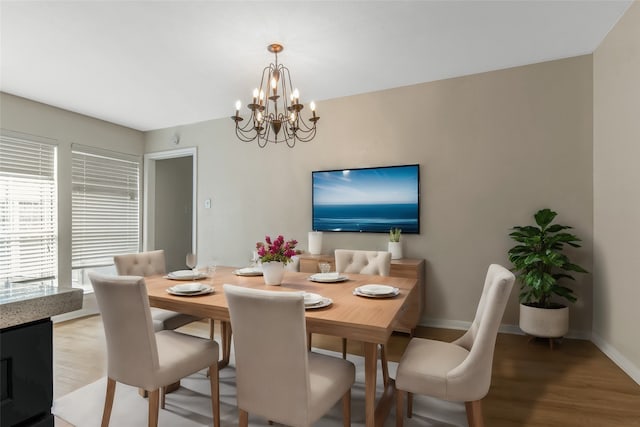 dining space with hardwood / wood-style flooring and a notable chandelier