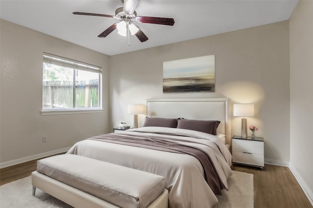 bedroom with wood finished floors, a ceiling fan, and baseboards