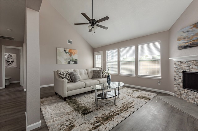 living room featuring hardwood / wood-style flooring, a fireplace, high vaulted ceiling, and ceiling fan