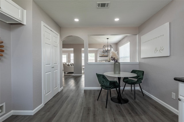 dining area featuring a notable chandelier and dark hardwood / wood-style flooring