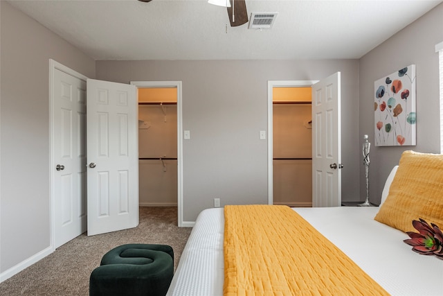 carpeted bedroom with a walk in closet, a closet, and ceiling fan