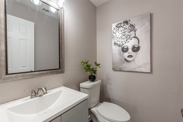 bathroom featuring toilet and vanity