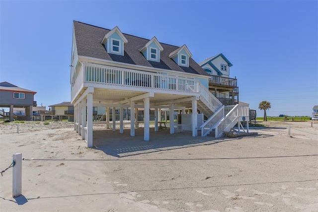 view of front of house with a carport, roof with shingles, and stairs