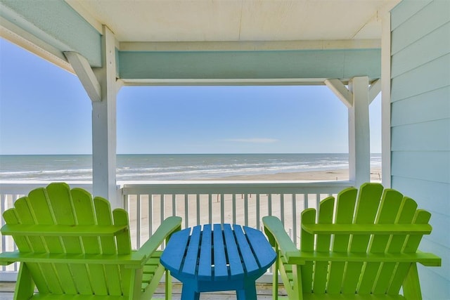 balcony featuring a water view and a beach view