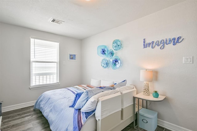 bedroom featuring dark wood-type flooring, visible vents, and baseboards