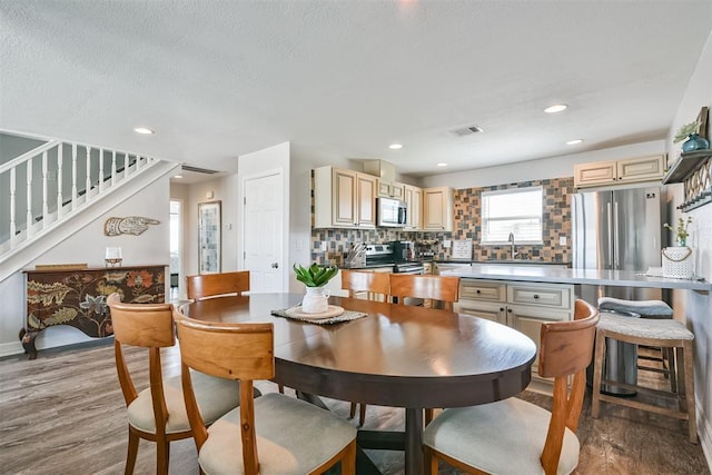 dining area featuring stairway, wood finished floors, visible vents, and recessed lighting