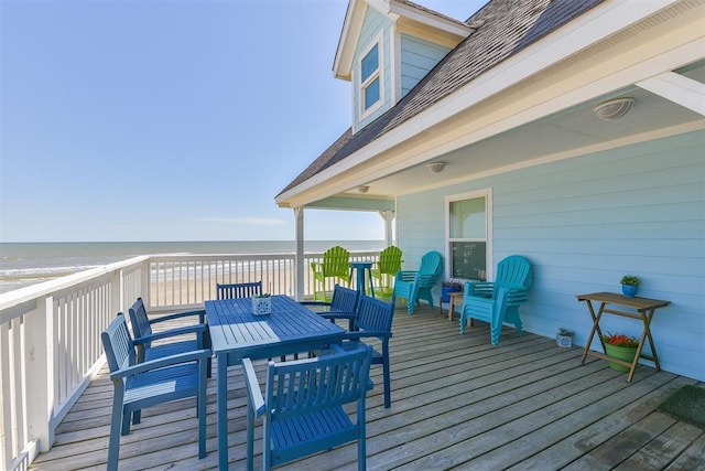 deck with a water view, a beach view, and outdoor dining area