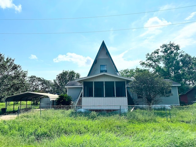 view of side of property with a sunroom and a carport