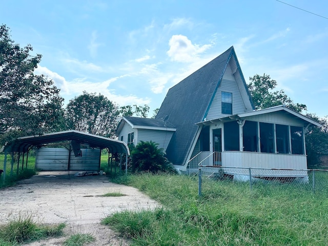 view of side of home with a carport and a sunroom