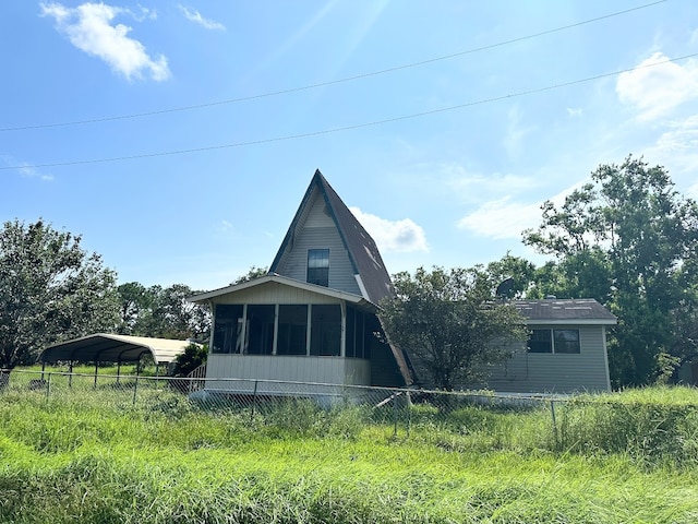 rear view of property with a carport and a sunroom