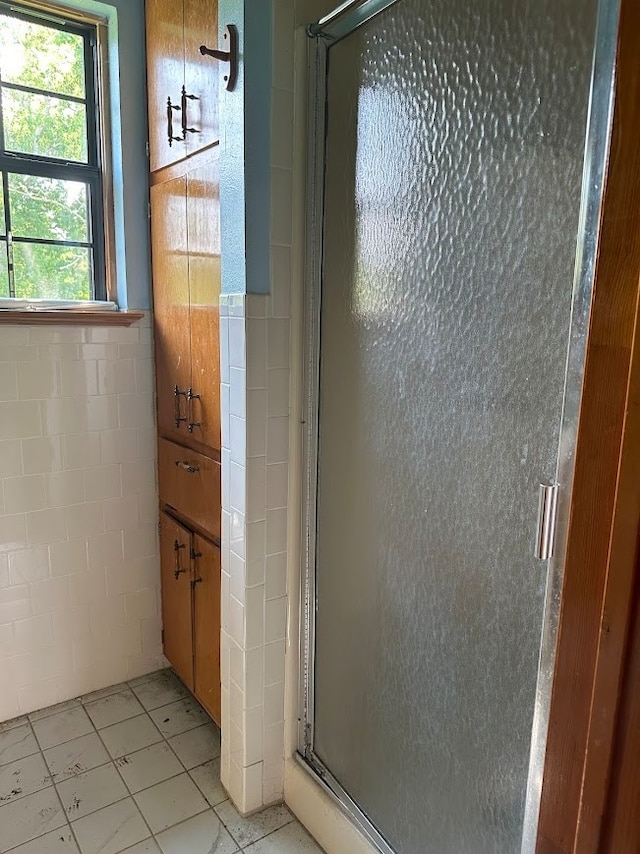 bathroom featuring tile patterned flooring and an enclosed shower