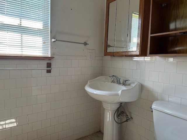 bathroom with tile walls, tile patterned floors, and toilet