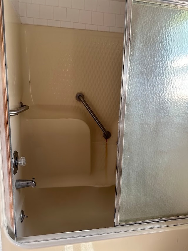 bathroom featuring shower / bath combination with glass door