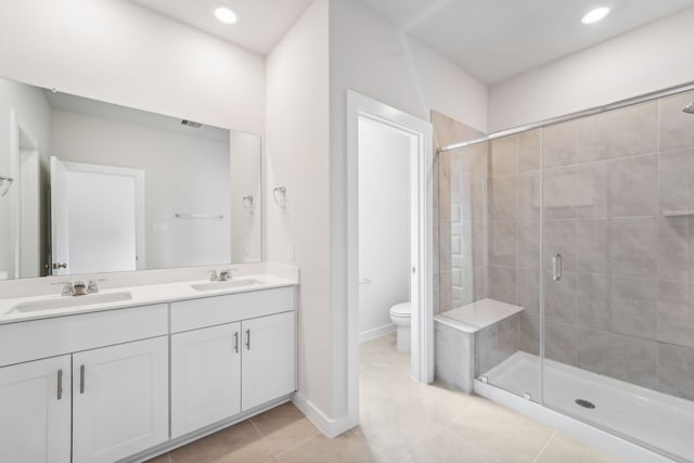 bathroom with tile patterned flooring, vanity, toilet, and a shower with shower door