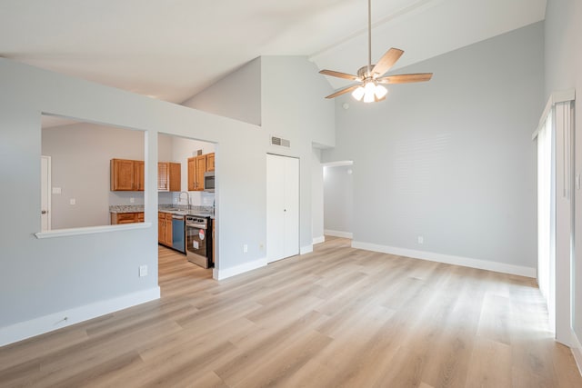 unfurnished living room featuring ceiling fan, high vaulted ceiling, light hardwood / wood-style flooring, and sink