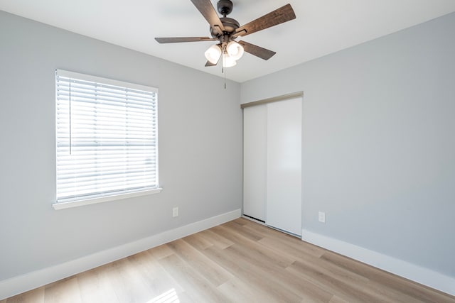 empty room with light wood-type flooring, a wealth of natural light, and ceiling fan