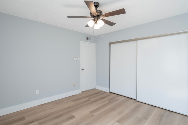 unfurnished bedroom with light hardwood / wood-style flooring, ceiling fan, and a closet