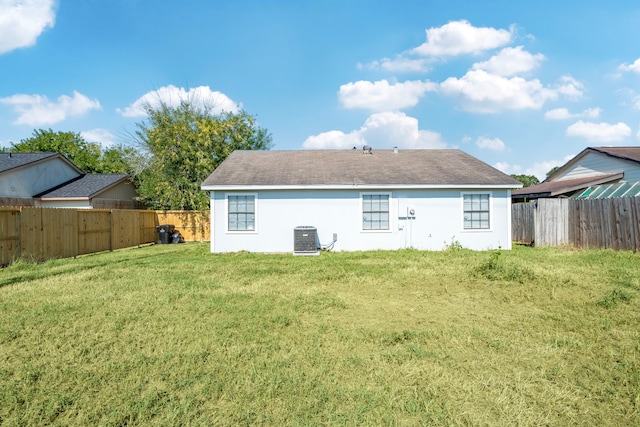 rear view of house featuring a yard and central AC