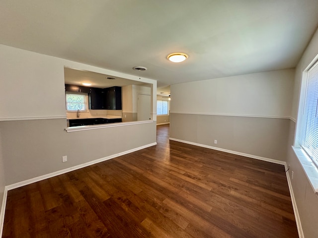 unfurnished living room with dark hardwood / wood-style flooring and a healthy amount of sunlight