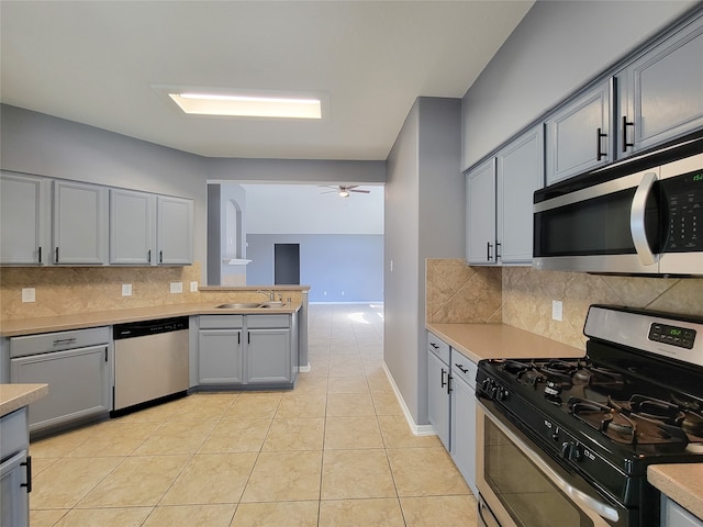 kitchen featuring tasteful backsplash, sink, stainless steel appliances, light tile patterned floors, and ceiling fan