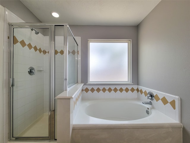 bathroom featuring a textured ceiling and plus walk in shower