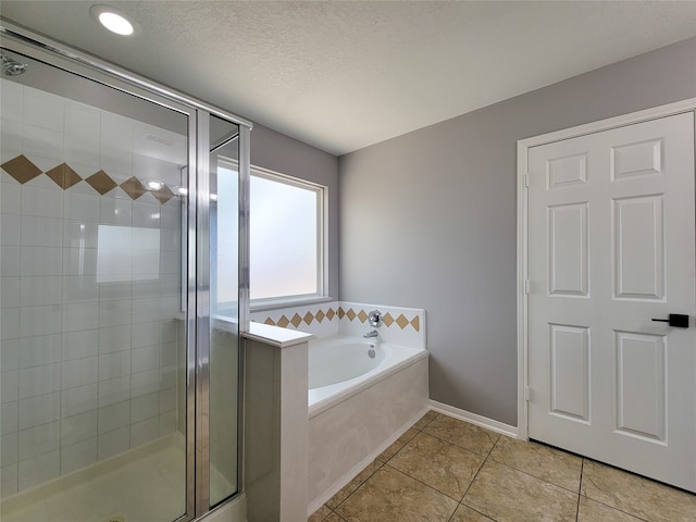 bathroom featuring a textured ceiling, separate shower and tub, and tile patterned floors