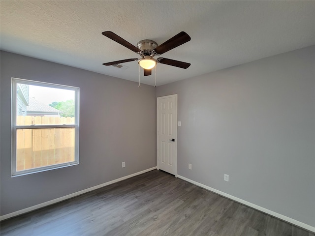 empty room with a textured ceiling, wood-type flooring, and ceiling fan