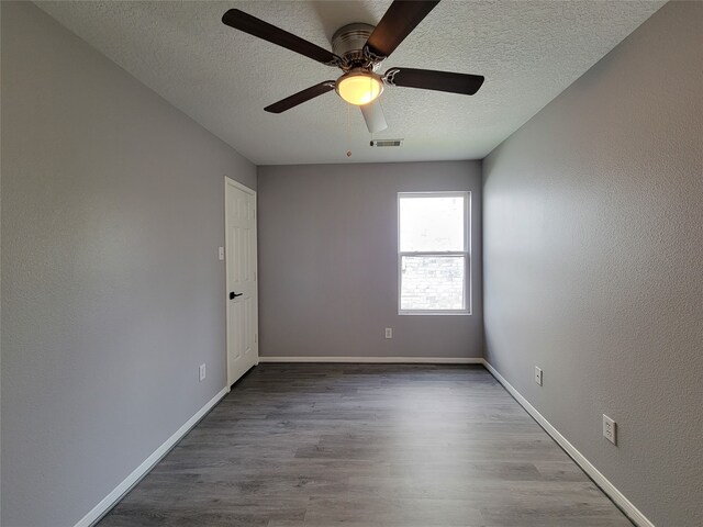 spare room with ceiling fan, a textured ceiling, and light hardwood / wood-style flooring