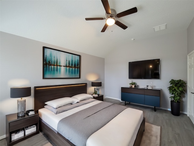 bedroom with ceiling fan, light hardwood / wood-style flooring, and lofted ceiling