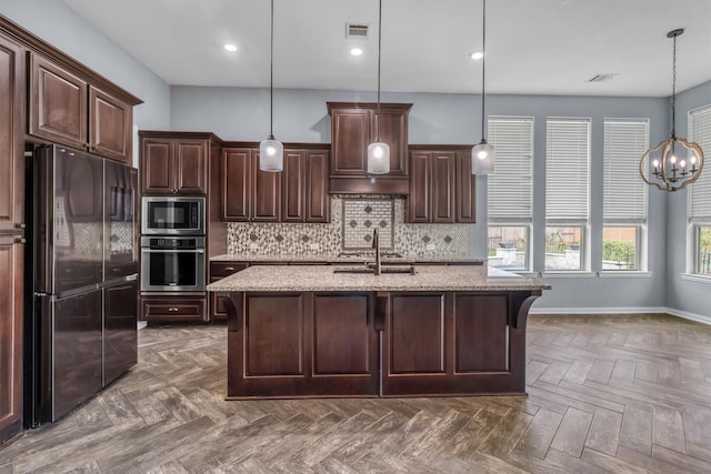 kitchen with a kitchen breakfast bar, dark brown cabinets, stainless steel appliances, pendant lighting, and a center island with sink