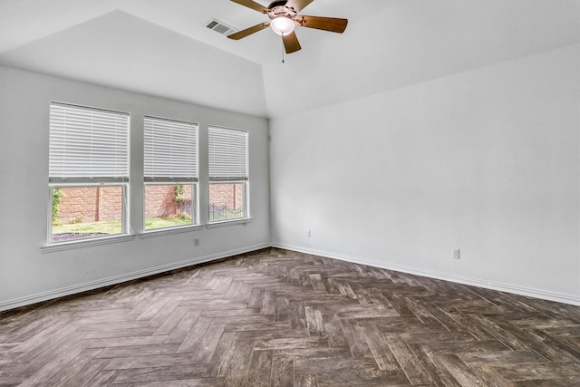 spare room with ceiling fan, dark parquet flooring, and a wealth of natural light