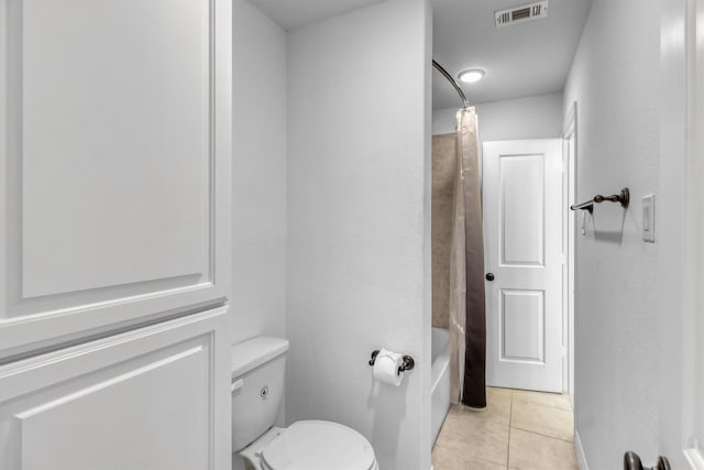 bathroom featuring tile patterned flooring, shower / bathtub combination with curtain, and toilet