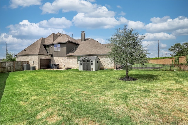 rear view of house with a lawn, cooling unit, and a storage shed