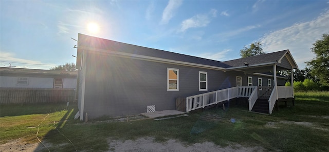 view of side of home featuring a deck and a lawn