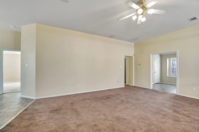 spare room featuring light carpet and ceiling fan