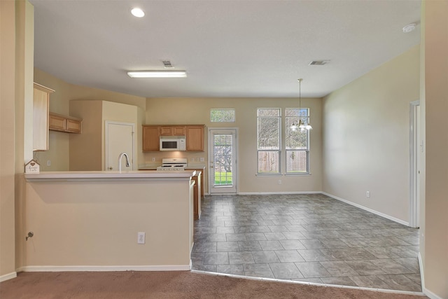 kitchen featuring sink, light brown cabinets, white appliances, and an inviting chandelier