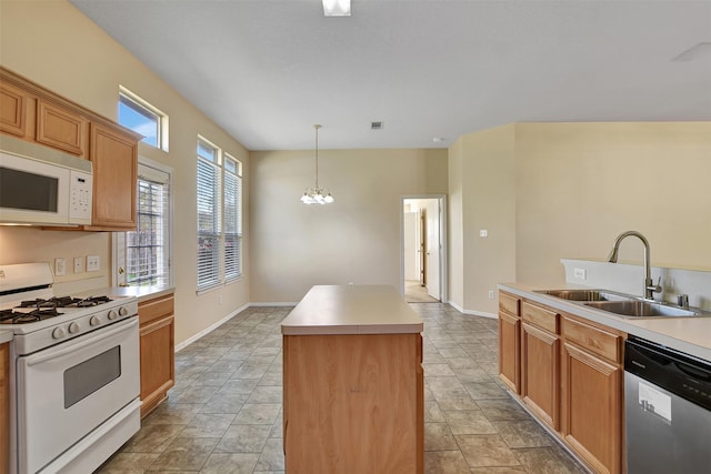 kitchen featuring a center island, sink, hanging light fixtures, an inviting chandelier, and white appliances