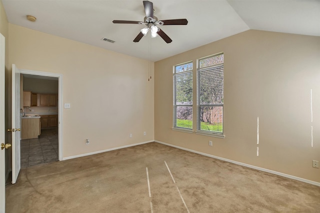 carpeted empty room with ceiling fan, sink, and lofted ceiling