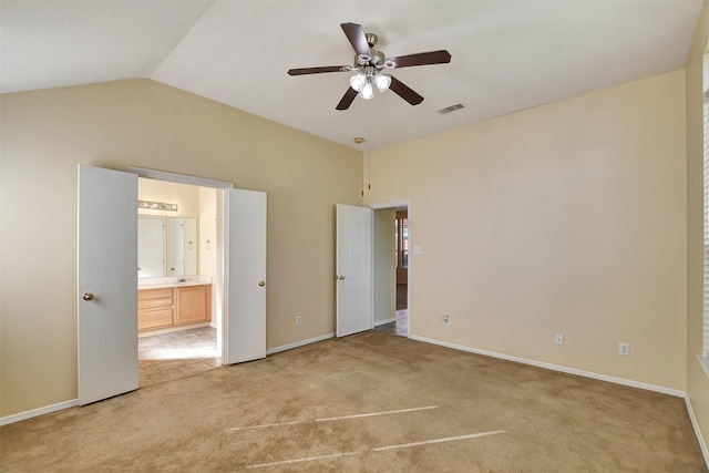 unfurnished bedroom featuring connected bathroom, ceiling fan, light carpet, and vaulted ceiling