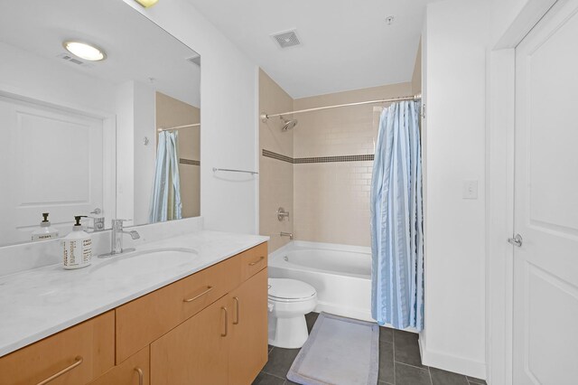 full bathroom with tile patterned floors, toilet, shower / bath combo with shower curtain, and vanity