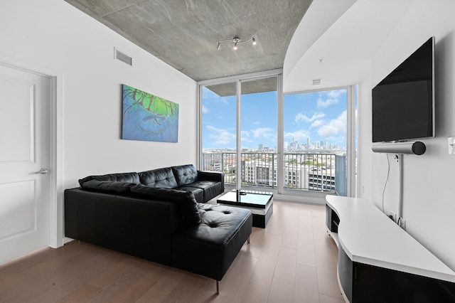 living room featuring a wall of windows, wood finished floors, and visible vents