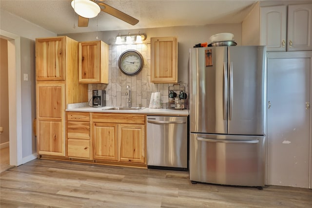 kitchen featuring light hardwood / wood-style floors, sink, stainless steel appliances, and decorative backsplash