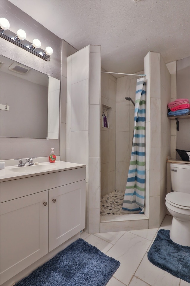 bathroom with tile patterned flooring, vanity, walk in shower, and toilet