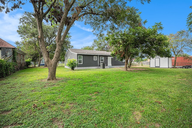 view of yard featuring central AC and a storage shed