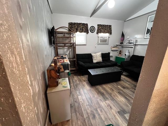 living room featuring vaulted ceiling, cooling unit, and hardwood / wood-style floors