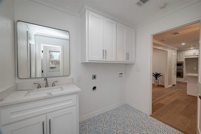 laundry area featuring electric dryer hookup, cabinets, sink, hookup for a washing machine, and ornamental molding