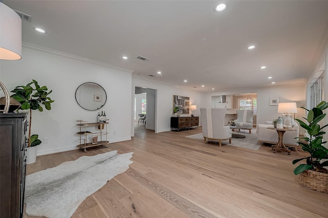 living room with light hardwood / wood-style flooring and crown molding