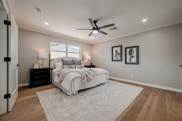 bedroom with ceiling fan, crown molding, and light hardwood / wood-style floors