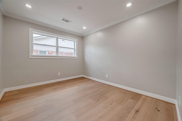 spare room featuring light wood-type flooring and ornamental molding